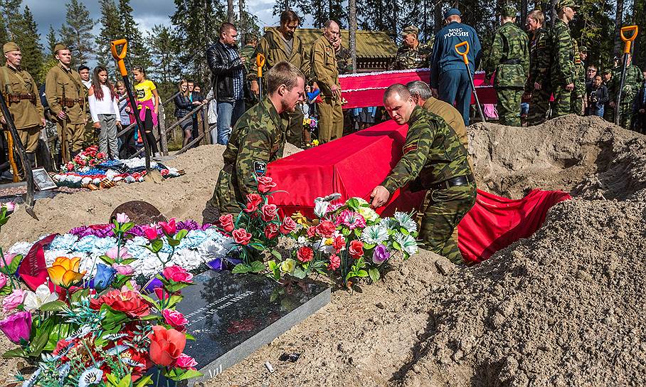 Каждый гроб с бойцом в землю опускают члены поискового отряда 