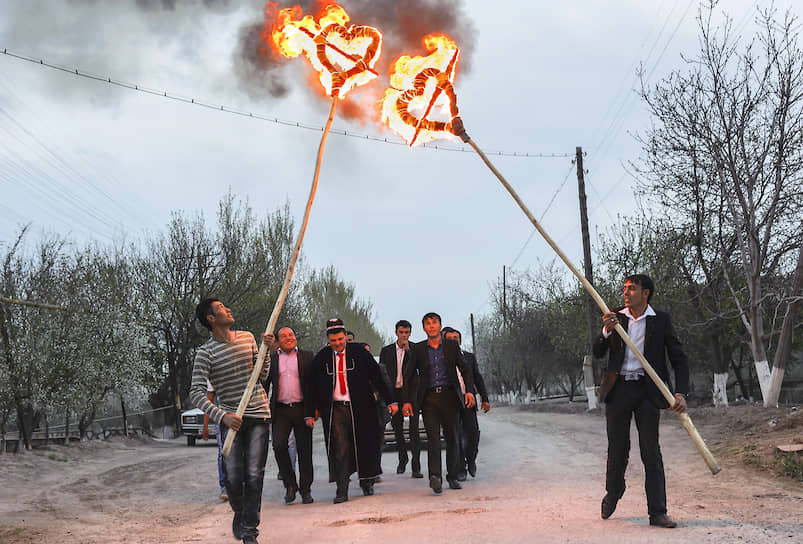 Жених с друзьями идет к дому невесты с зажженными факелами