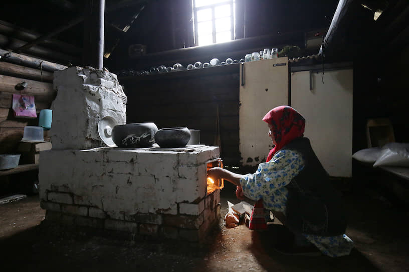 Удмуртия. 87-летняя жительница деревни Карамас-Пельга разжигает печь в куале — летнем доме,
где готовят, едят и молятся духам