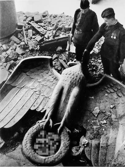 Советские солдаты у поверженного орла на развалинах имперской канцелярии Третьего рейха в Берлине