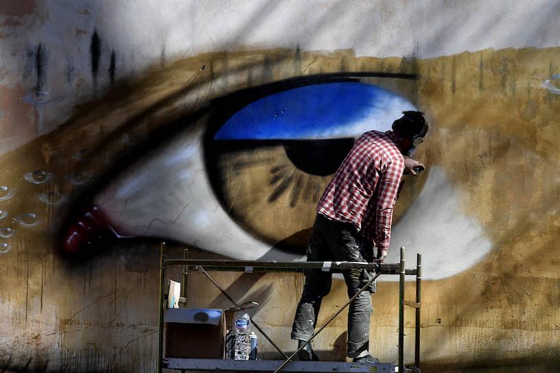 Беречь глаза при цифровом образе жизни становится все сложнее (на фото — уличный художник и его работа в Риме)