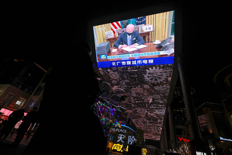 Трансляция на уличном экране в Пекине. Новый президент США Джо Байден подписывает распоряжения в Белом доме 