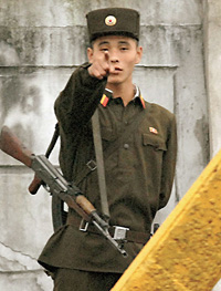 Северокорейский солдат на границе с Китаем напоминает фотографу, что снимать здесь запрещено