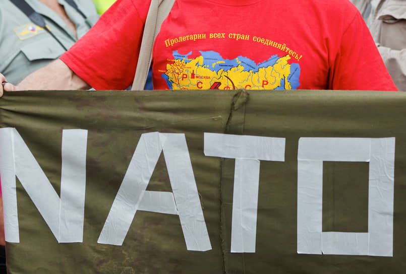 Мужчина в футболке с картой бывшего Советского Союза держит плакат на акции протеста против НАТО. Варшава, 2016 год.