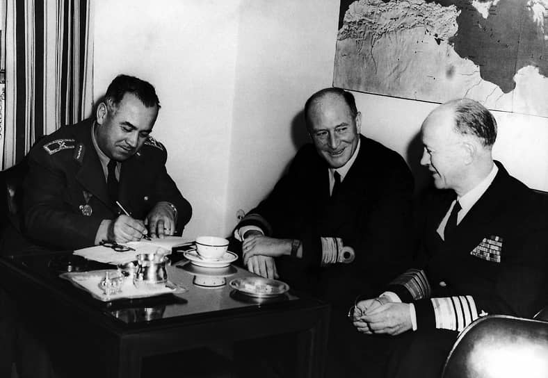 Турецкий генерал Сахап Гурлер (слева) расписывается в гостевой книге в штаб-квартире командования НАТО в Южной Европе. Контр-адмирал Азиас Улусон (по центру) и адмирал Роберт Карни (справа). 1952 год.