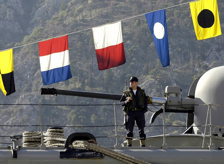 Греческий солдат охраняет корабль HS Bouboulina, стоящий на якоре в черногорском порту Котор в рамках визита средиземноморского флота НАТО в Сербию и Черногорию. 2004 год.