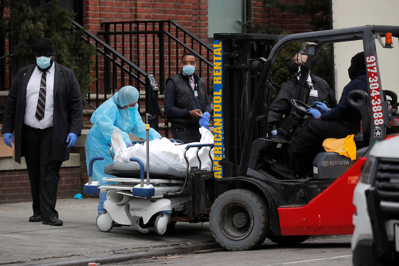 Рабочие готовятся погрузить умершего человека в трейлер во время вспышки COVID-19 в Бруклинском районе Нью-Йорка. 30 марта 2020 года.