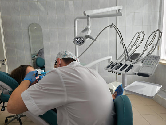 Стоматолог проводит осмотр пациента