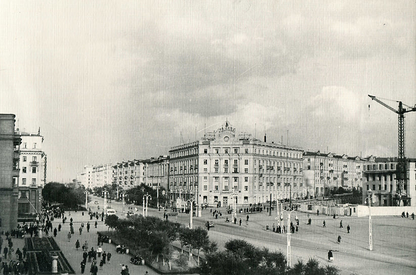 Перспектива улицы Спартака. В центре — жилой дом для работников радиозавода с магазином «Ритм». 1956 год. Здание было построено в стиле неоклассицизма. Проект разработан в 1950-1951 годах, а строительство завершено в 1953 году. В 1954 году на первом этаже открылся магазин «Культтовары», переименованный в «Ритм» в середине 1960-х. Магазин стал популярен благодаря отделу грампластинок и музыкальных инструментов. С конца 1960-х годов «Ритм» стал популярным местом для встреч и свиданий.