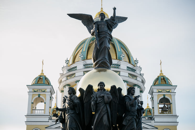 Скульптурная композиция включает семь архангелов, которые держат на крыльях сферу, символизирующую мироздание. На шаре возвышается фигура архангела Михаила