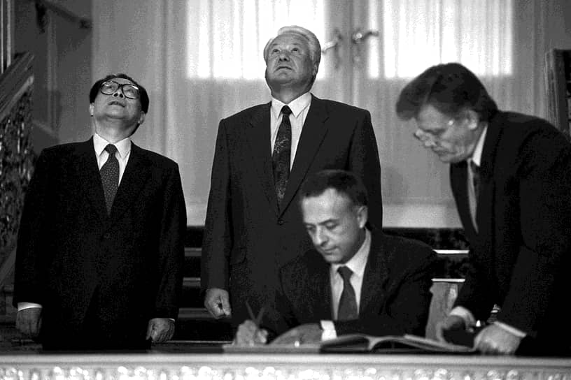 Министр иностранных дел России Андрей Козырев (сидит) во время встречи Президента России Бориса Ельцина (в центре стоит) и главы КНР Цзянь Цзэминя (слева). Встреча прошла в Кремле в 1994 году

