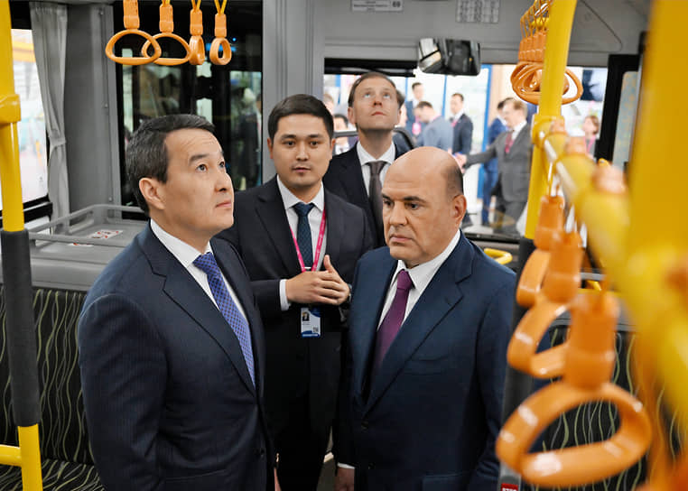 Председатель правительства России Михаил Мишустин (справа), премьер-министр Казахстана Алихан Смаилов (слева) и министр промышленности и торговли России Денис Мантуров (второй справа) на выставке
