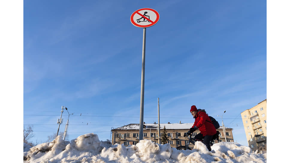 Виды Екатеринбурга. Мужчина едет на велосипеде между сугробов