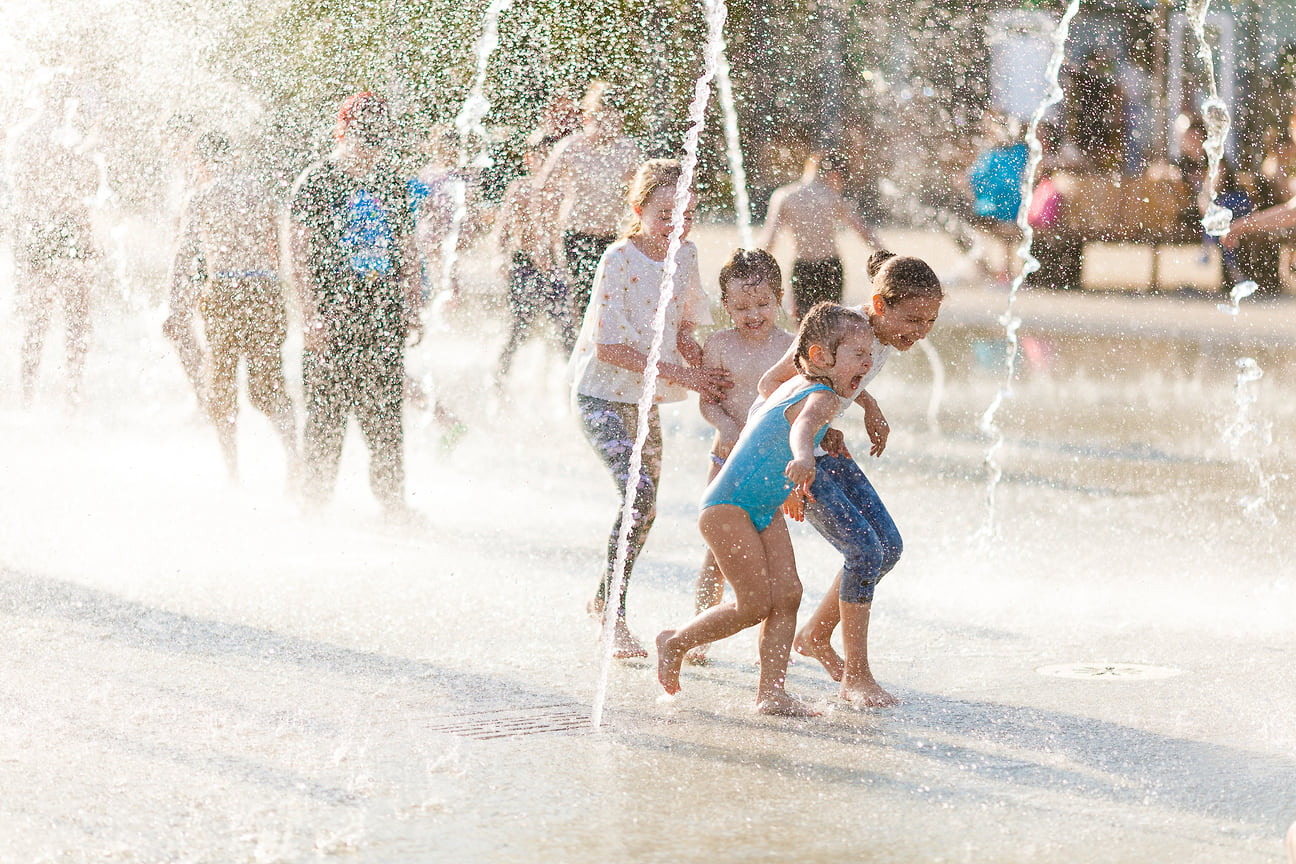 Местные дети спасаются от солнца в фонтанах на Центральной площади.