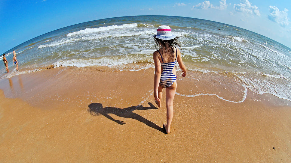 Маленькая девочка на берегу Азовского моря. Краснодарский край, Темрюкский район, пляж в поселке Пересыпь. Июль 2013 года
