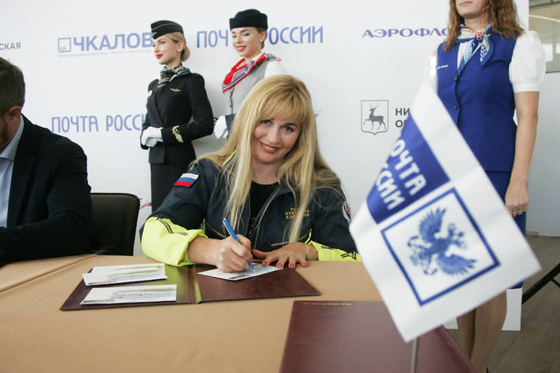 Пилот Светлана Капанина подписывает блок марок, посвященных юбилею