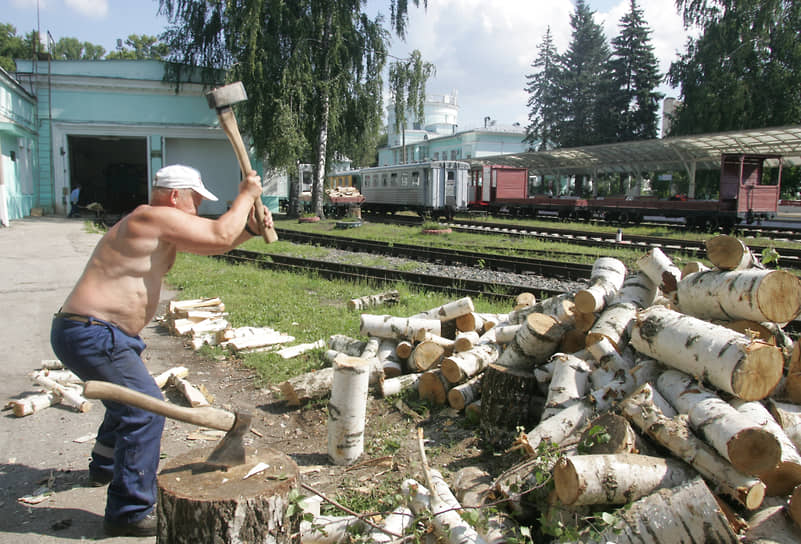 Рабочий рубит дрова для паровоза