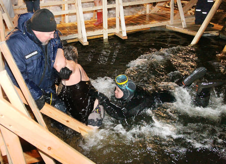 Дежурный водолаз эвакуирует из крещенской проруби женщину, внезапно почувствовавшую недомогание