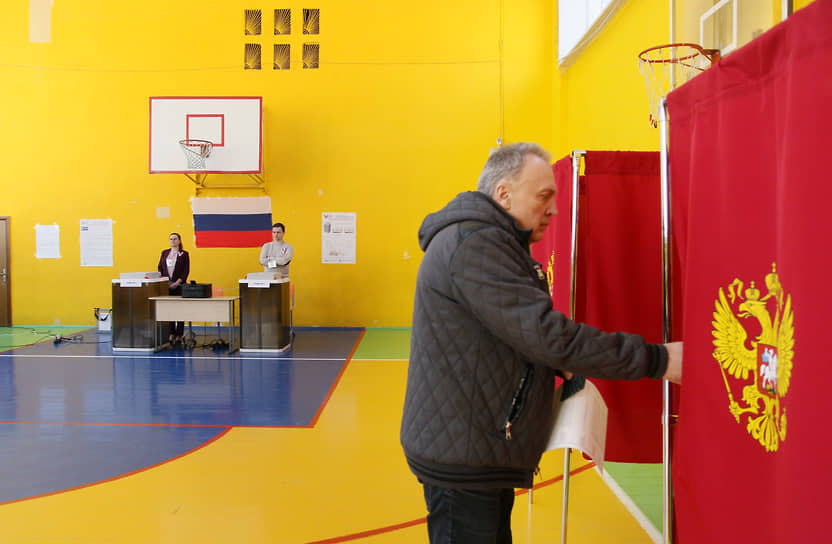 Избиратель заходит в кабинку для голосования на участке в спортивном зале школы №40