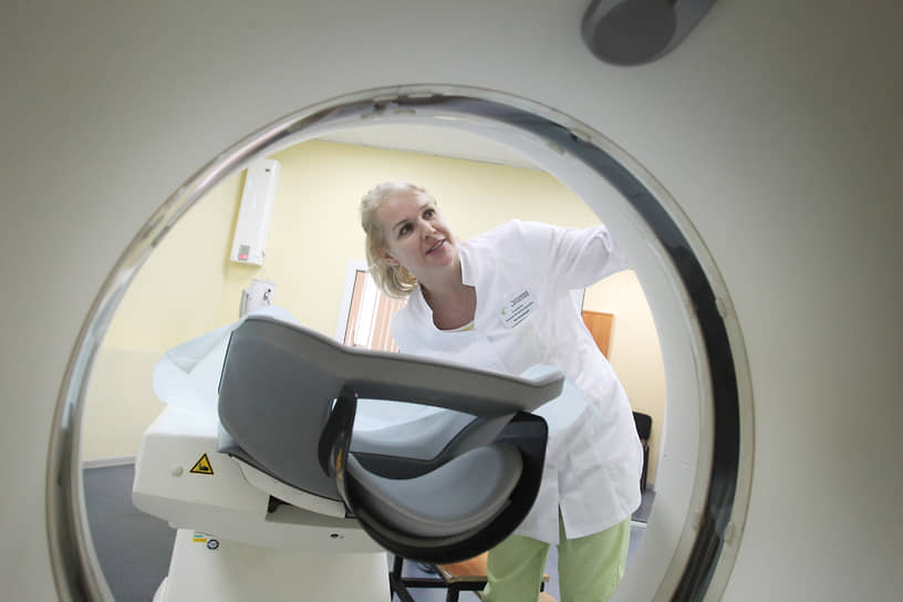 Медсестра осматривает компьютерный томограф