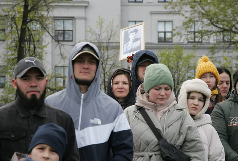 Зрители с портретом из Бессмертного полка, который в этом году решили проводить в онлайн-формате