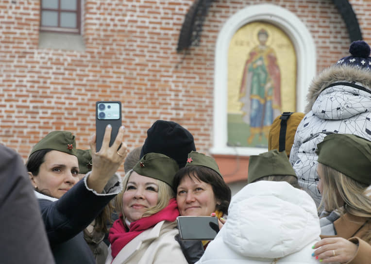 Зрители снимают селфи на фоне парада