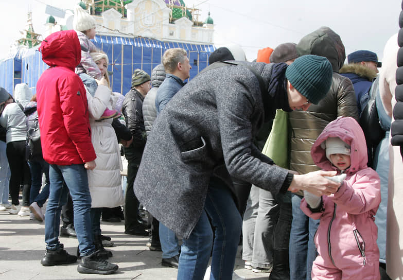 Мужчина надевает ребенку варежки