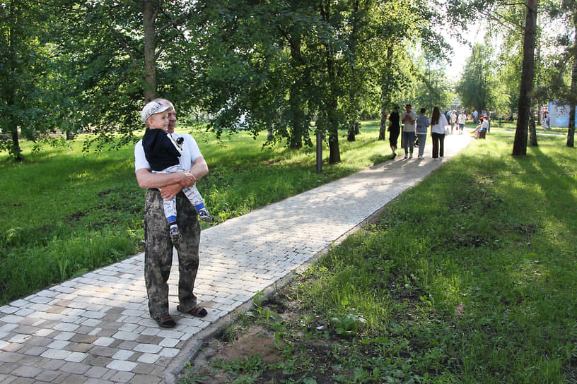 Местный житель с ребенком на руках гуляет по парку