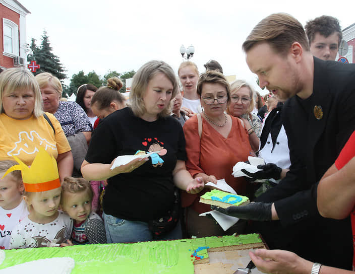 Министр туризма и промыслов Нижегородской области Сергей Яковлев (справа) раздает торт посетителям ярмарки