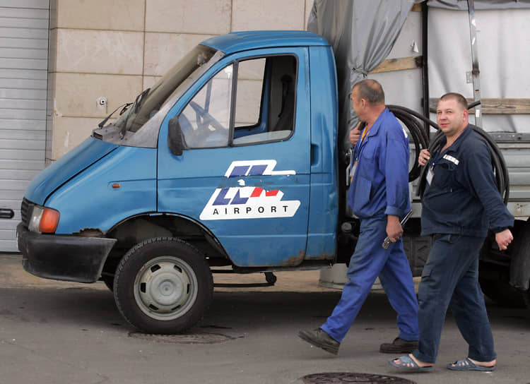 Монтеры идут мимо &quot;ГАЗели&quot; с символикой нижегородского аэропорта &quot;Стригино&quot;