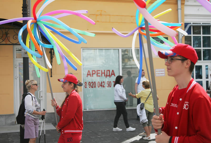 Колонна аниматоров с разноцветными украшениями