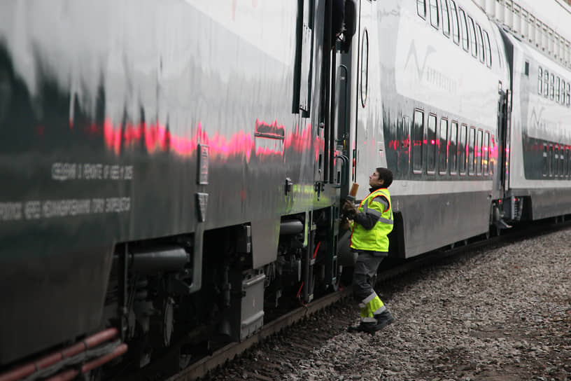 Рабочий обслуживает автосцепку локомотива