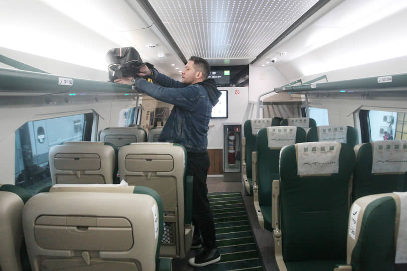 Пассажир укладывает багаж на полку