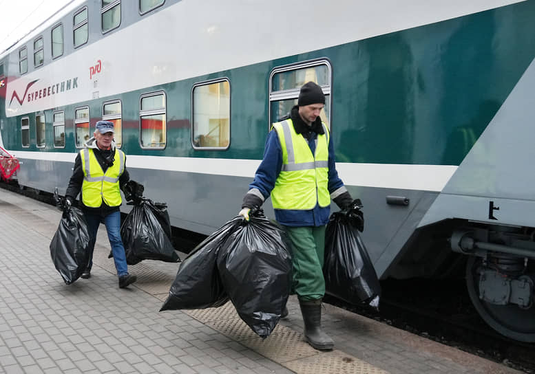 Рабочие выносят мусор из поезда
