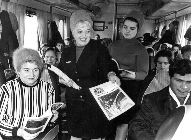 Проводница раздает журналы пассажирам