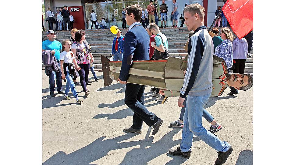 Молодые люди несут картонную фигуру Сталина в Барнауле