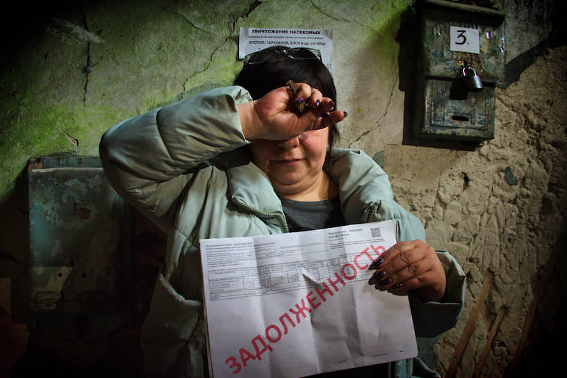 Жительница аварийного дома в Барнауле с квитанцией о задолженности по коммунальным платежам