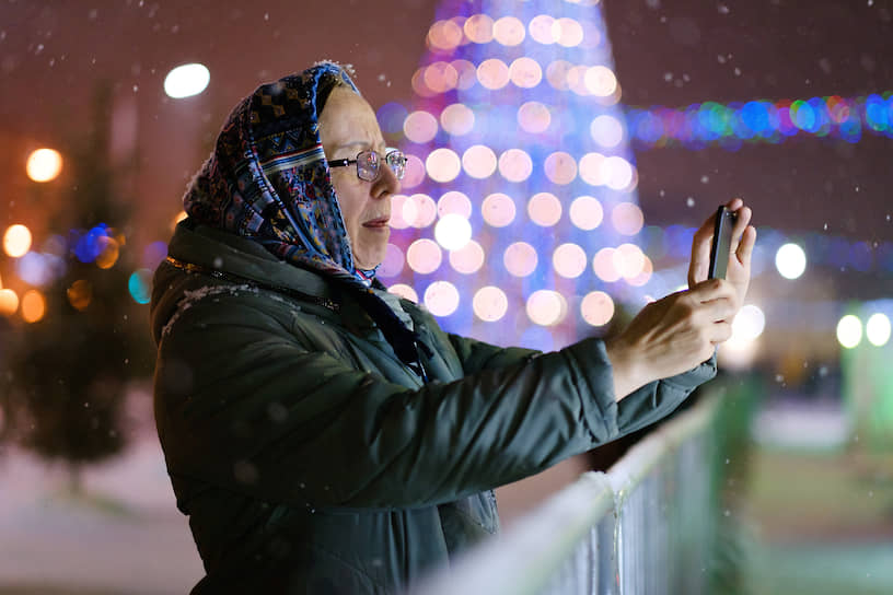 Женщина фотографируется на фоне новогодних украшений в Томске