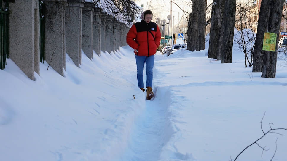 Житель Барнаула идет по расчищенной тропинке на улице Анатолия