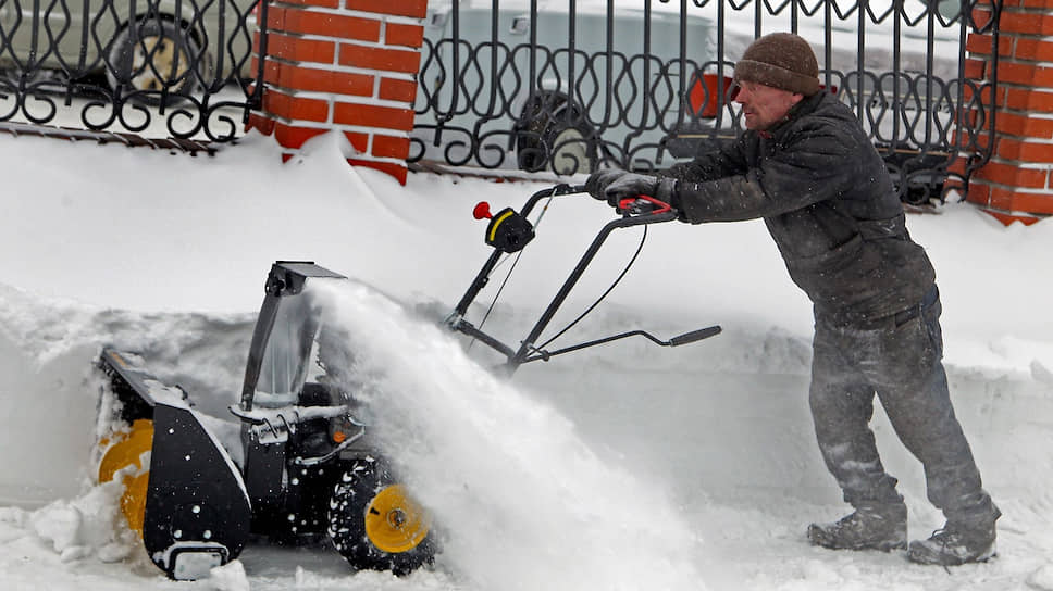 Работник коммунальной службы чистит тротуар от снега в центре Барнаула