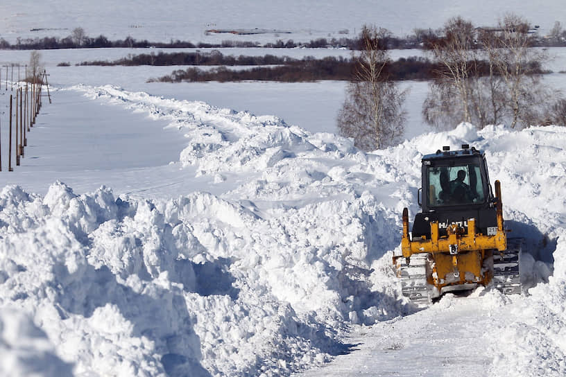 Спецтехника чистит занесенную снегом дорогу к селу Барановка Алтайского края
