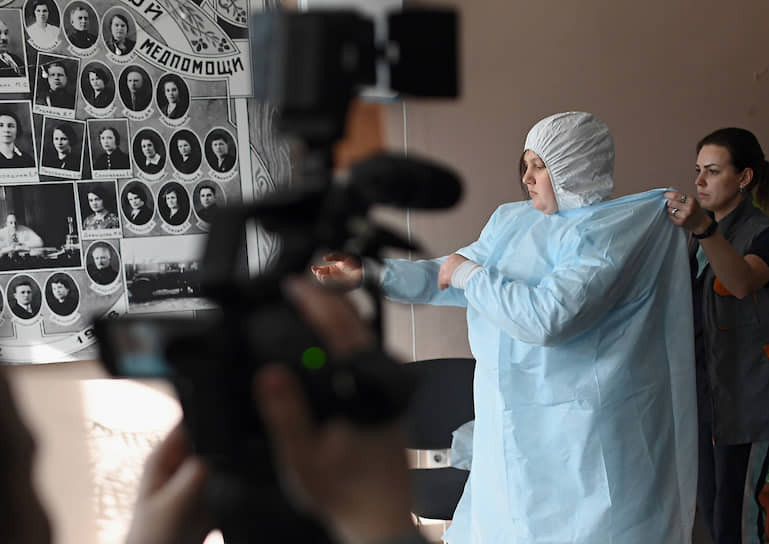 Сотрудница скорой помощи надевает защитный костюм для транспортировки больного с подозрением на коронавирус в Омске. В регионе зафиксировано восемь случаев заражения COVID-19