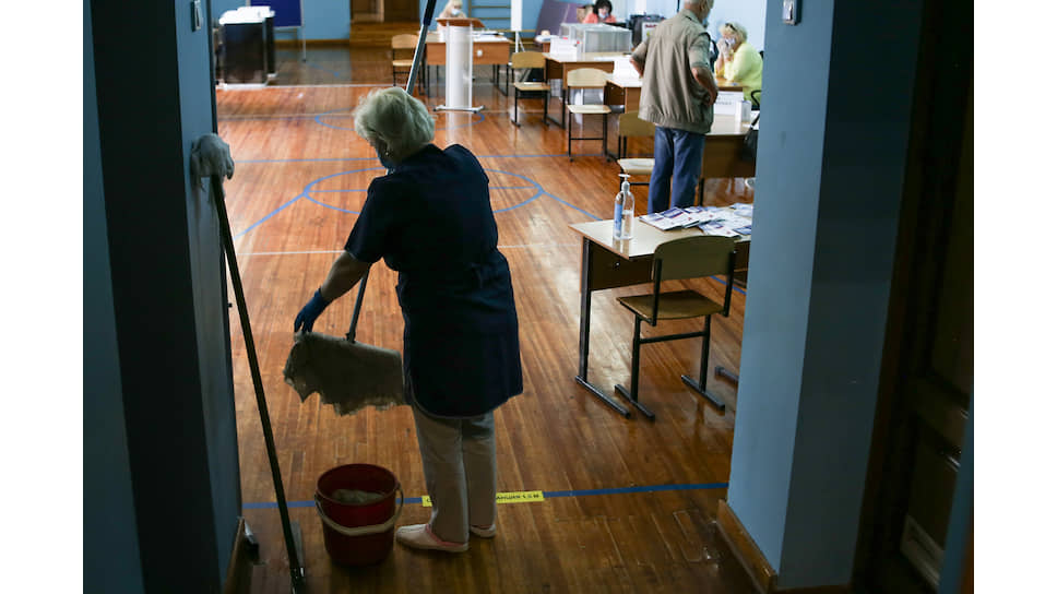 Сотрудница клининговой службы во время влажной уборки на избирательном участке