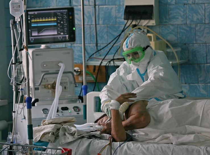 Работа сотрудников больницы в «красной зоне», где лежат пациенты, инфицированные коронавирусом. Жанровая фотография. Сотрудники больницы в защитных костюмах во время работы в отделении интенсивной терапии