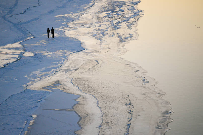 Начало весеннего ледохода на Оби. Люди гуляют на краю льдины во время заката