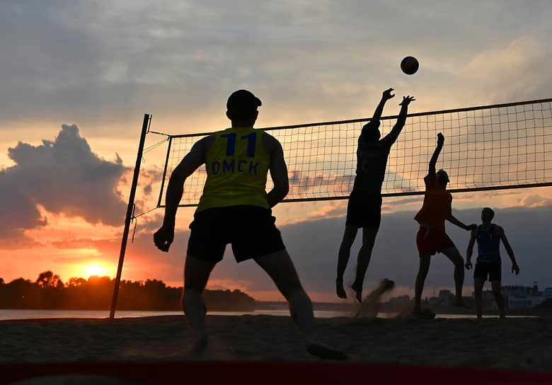 Молодые люди играю в волейбол на Центральном пляже на берегу реки Иртыш в Омске