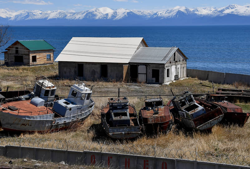 Заброшенный дом и старые катера на берегу озера Байкал в Нижнеангарске
