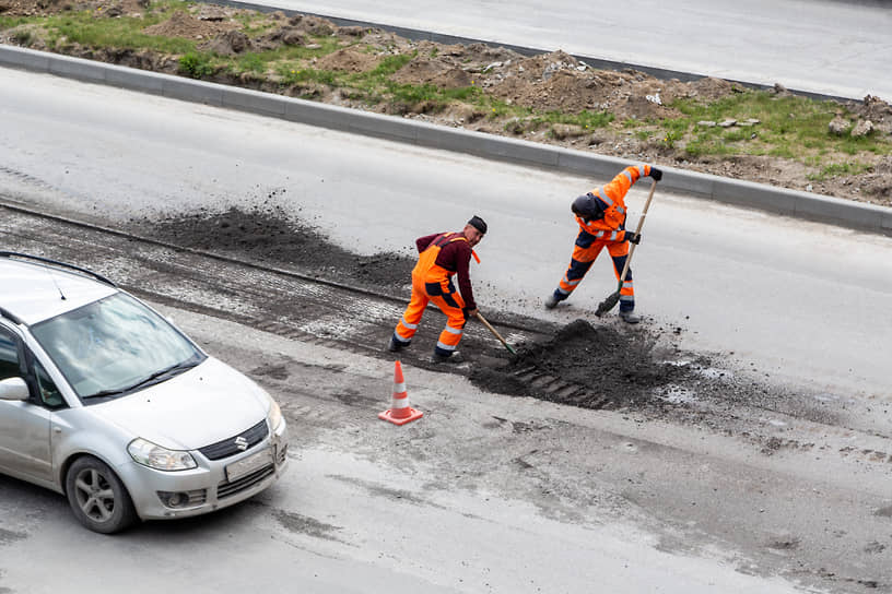 Сотрудники дорожных служб ремонтируют дорожное покрытие на Ипподромском шоссе в Новосибирске