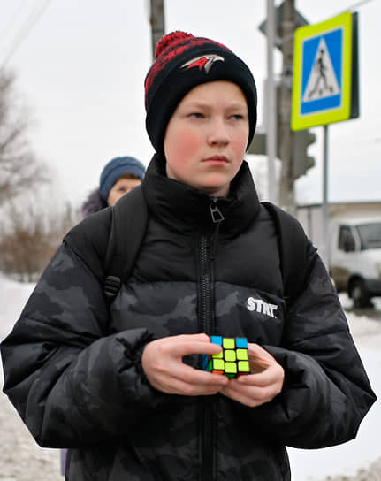 Житель Омска в шапке с символикой хоккейного клуба &quot;Авангард&quot; с кубиком Рубика в руках.