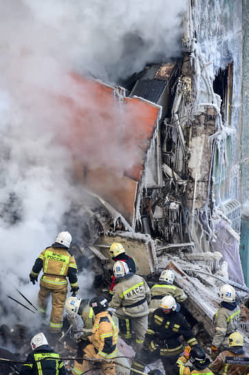 Сотрудники МЧС России и Муниципальной аварийно-спасательной службы (МАСС) во время разбора завалов после взрыва газа в жилом доме на улице Линейная, 39 в Новосибирске.